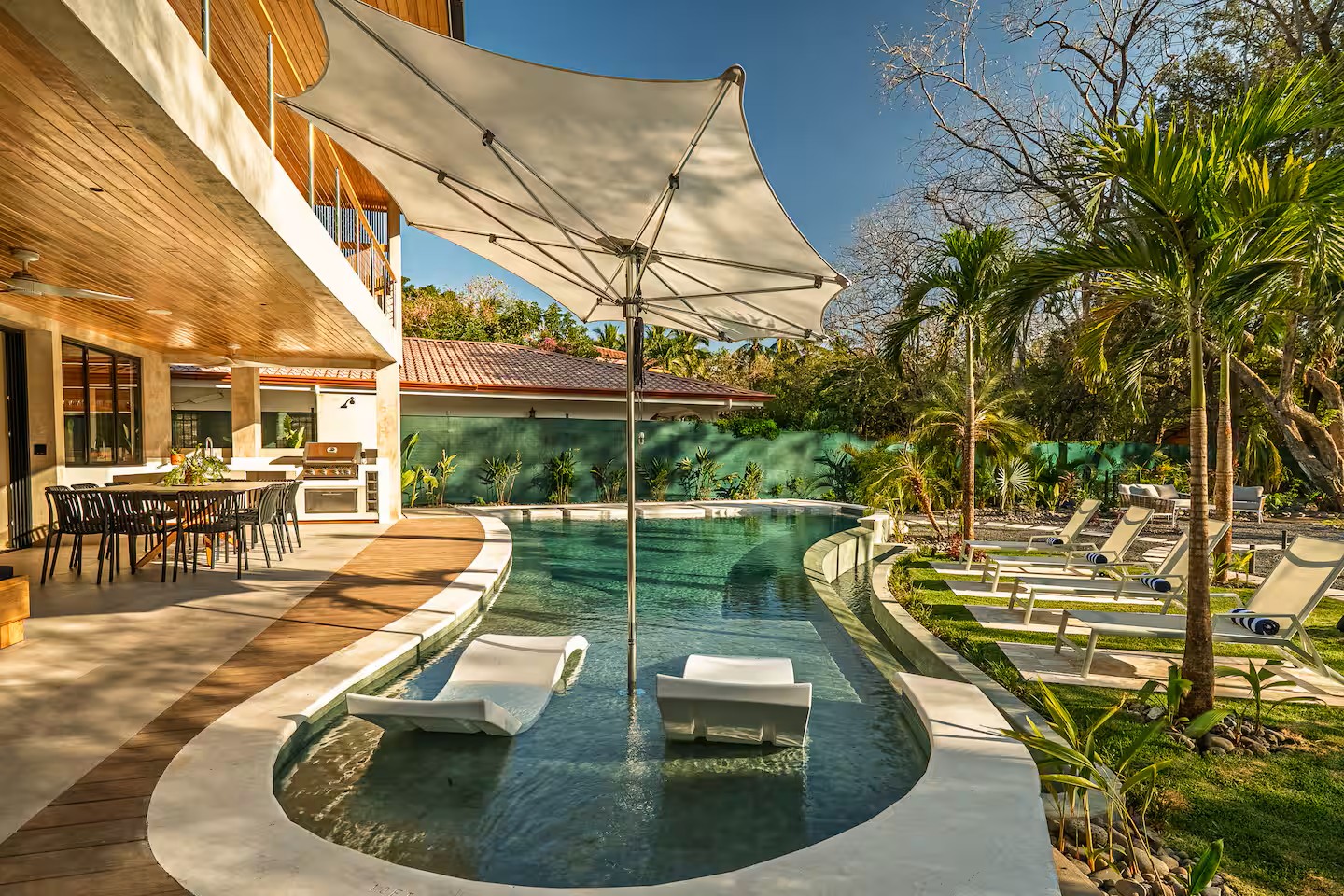 Curved pool with in-water loungers beside the deck, Villa Viva landscape, Playa Grande